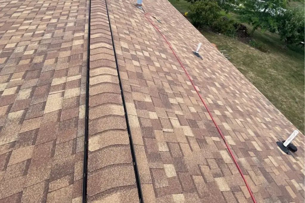 Affect Roof Lifespan - My Topp Home Aerial view of a brown shingle roof with a red chalk line running along the slope and vents nearby. - My Topp Home