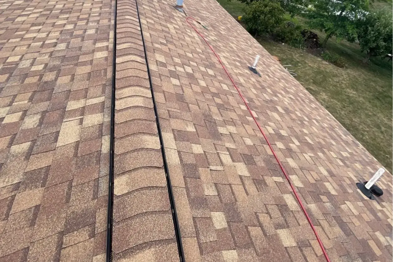 Aerial view of a brown shingle roof with a red chalk line running along the slope and vents nearby. - My Topp Home