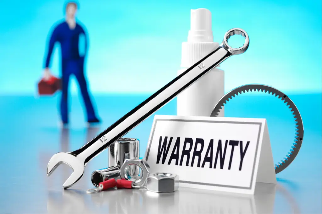 Roof Warranty - My Topp Home Close-up of repair tools and a 'WARRANTY' sign, with a blue-clad technician blurred in the background. - My Topp Home