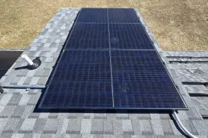 Rooftop solar panels mounted on gray shingle roof with a vent pipe nearby and electrical conduit along the edge. - My Topp Home